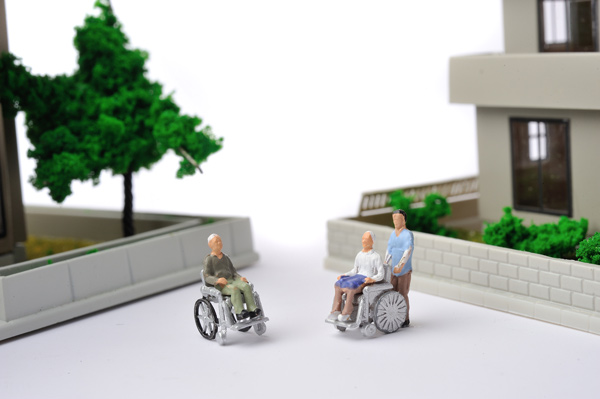車いすに乗る高齢者と住宅街